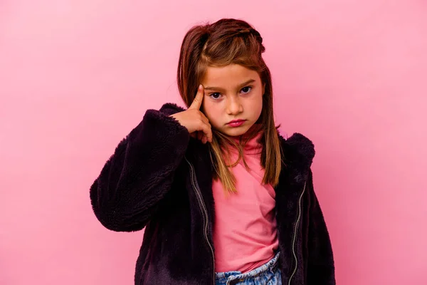 Маленька Біла Дівчинка Ізольована Рожевому Тлі Вказуючи Храм Пальцем Думаючи — стокове фото