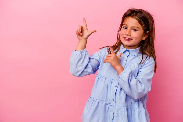 손가락으로 공간을 가리키는 분홍색 배경에 고립된 코카서스 소녀는 욕망을 표현하면서 — 스톡 사진