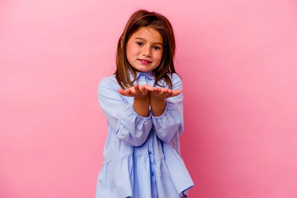 ピンクの背景に孤立した小さな白人の女の子ヤシの木で何かを保持し カメラに提供 — ストック写真