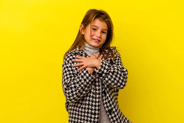 黄色の背景に隔離された小さな白人の少女は 胸に手のひらを押して優しい表情をしています 愛の概念 — ストック写真