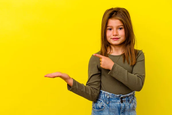 Pequena Menina Caucasiana Isolado Fundo Amarelo Animado Segurando Espaço Cópia — Fotografia de Stock