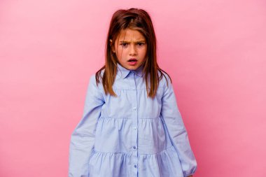 Pembe arka planda izole edilmiş küçük beyaz kız çok sinirli ve agresif çığlıklar atıyor..