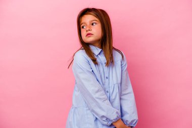 Pembe arka planda izole edilmiş küçük beyaz kız hedeflere ve amaçlara ulaşmayı hayal ediyor.