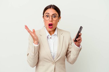 Beyaz arka planda izole edilmiş cep telefonu tutan genç iş kadını şaşırdı ve şok oldu..