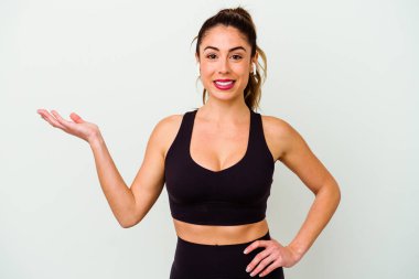 Beyaz arka planda izole edilmiş beyaz tenli genç bir kadın bir palmiye üzerinde fotokopi alanı ve belinde bir el daha tutuyor..