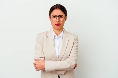 Beyaz arka planda izole edilmiş genç beyaz kadın kameraya alaycı bir ifadeyle bakıyor..