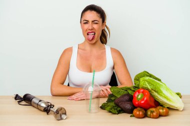 Genç, beyaz bir kadın sebzeli sağlıklı bir smoothie hazırlıyor..