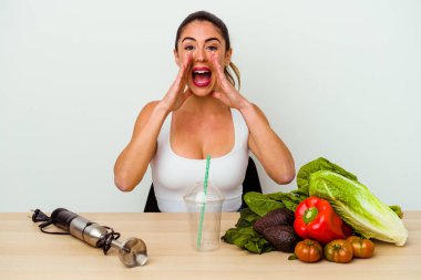 Genç, beyaz bir kadın sebzeli sağlıklı bir smoothie hazırlıyor..