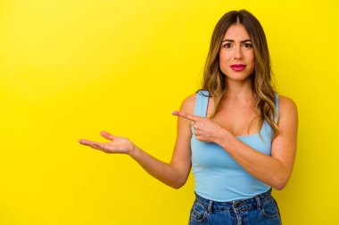 Sarı arka planda izole edilmiş beyaz bir kadın. Elinde palmiye ağacının fotokopisini tutarken heyecanlı..