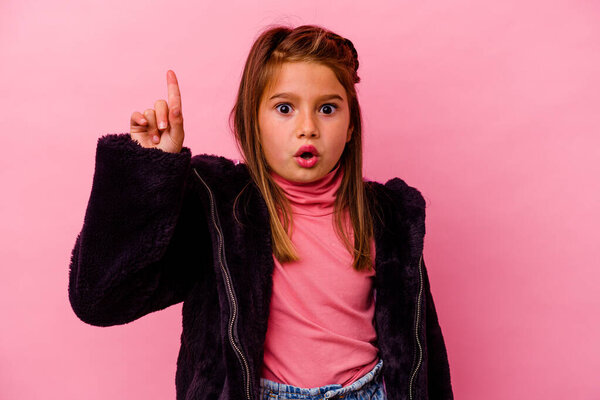 Little caucasian girl isolated on pink background  having some great idea, concept of creativity.