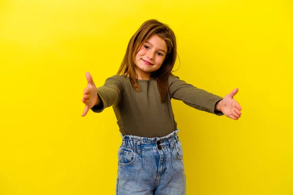Pequena Menina Caucasiana Isolado Fundo Amarelo Segurando Algo Com Ambas — Fotografia de Stock
