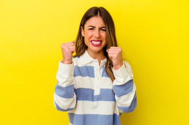 Sarı arka planda izole edilmiş genç beyaz kadın gergin elleriyle çığlık atıyor..