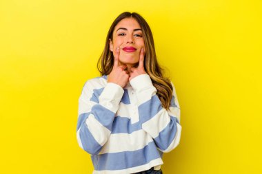 Sarı arka planda izole edilmiş beyaz bir kadın iki seçenek arasında şüphe duyuyor..