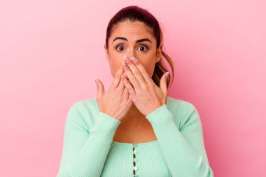 Pembe arka planda izole edilmiş genç beyaz kadın zaferi, tutkuyu ve coşkuyu kutluyor, mutlu bir ifade..