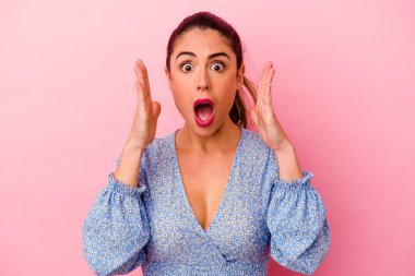 Genç, beyaz bir kadın pembe arka planda izole edilmiş. Durağan yaşam tarzından dolayı boyun ağrısı çekiyor..