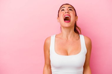 Pembe arka planda izole edilmiş beyaz bir kadın zaferden sonra yumruğunu kaldırıyor, kazanan konsept.