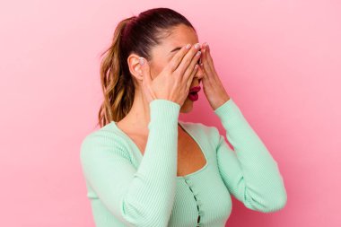 Pembe arka planda soyutlanmış genç beyaz bir kadın özel bir günü kutluyor, atlıyor ve enerjiyle kollarını kaldırıyor..