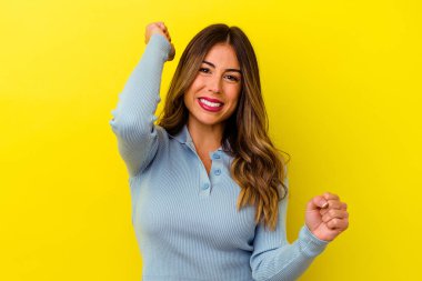 Sarı arka planda izole edilmiş genç beyaz kadın dans ediyor ve eğleniyor..