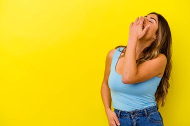 Sarı arka planda izole edilmiş genç beyaz kadın gülüyor, kaygısız, doğal duygu..