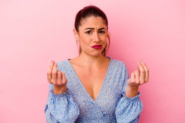 Pembe arka planda izole edilmiş beyaz bir kadın şans getirsin diye dua ediyor.