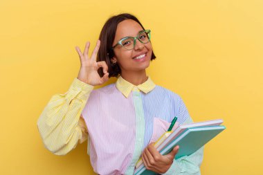 Sarı arka planda izole edilmiş genç bir ırk öğrencisi. Neşeli ve kendinden emin..