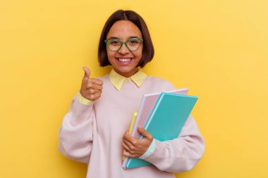 Sarı arka planda soyutlanmış genç ırk öğrencisi kadın.
