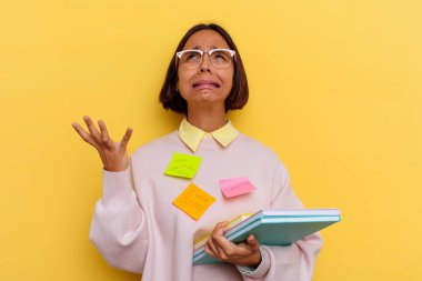 Sarı arka planda çok meşgul, melez bir genç kız öğrenci.