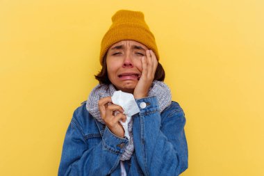 Sarı arka planda soğuk algınlığı olan genç melez bir kadın.
