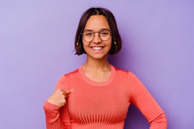 Mor arka planda izole edilmiş genç bir ırk kadını gömlek fotokopisini elle gösteriyor, gururlu ve kendinden emin.