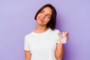 Mor zemin üzerinde bir bardak su tutan genç melez ırk amaçlarına ve amaçlarına ulaşma hayali kuruyor.