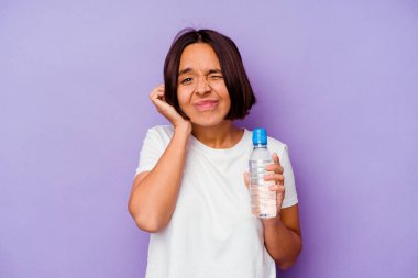 Mor arka planda izole edilmiş su şişesi tutan melez bir ırk kulakları elleriyle kapatıyor..