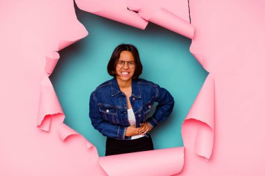 Kırık bir geçmişin arkasındaki genç melez kadın şok olmuş, ağzı ellerle kaplanmış, yeni bir şey keşfetmeye hevesli..