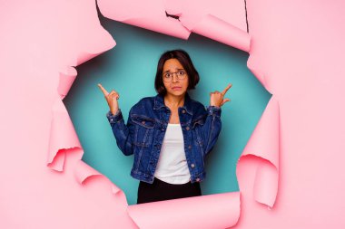 Kırık arka planda genç bir ırk kadını parmaklarıyla kulaklarını kapatıyor, gürültülü bir ortam yüzünden stresli ve çaresiz..