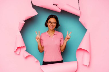 Kırık arka planda genç melez bir kadın şakağı parmağıyla işaret ediyor, düşünüyor ve bir göreve odaklanıyor..