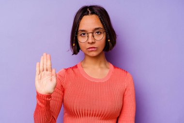 Mor arka planda izole edilmiş genç bir ırk kadını elini uzatmış, dur işareti göstererek seni engelliyor..