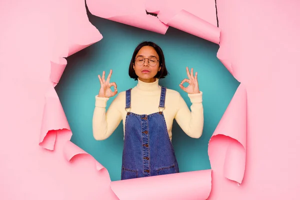 Young mixed race woman behind a broken background keeping a secret or asking for silence.