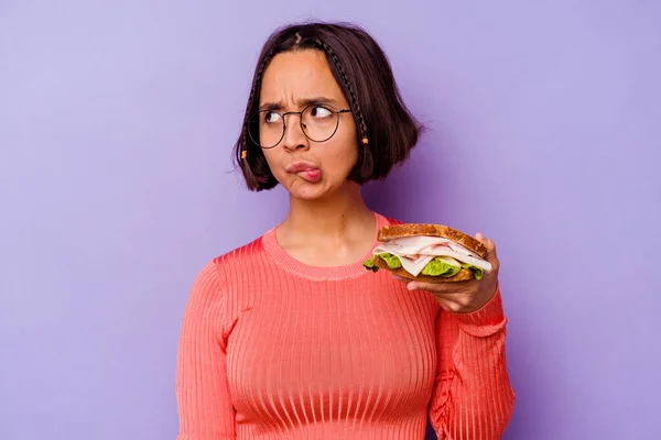 Young Mixed Race Woman Holding Sandwich Isolated Purple Background Confused — Stock Photo, Image