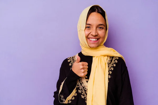 紫の背景の笑顔と親指を上げる上に隔離された典型的なアラビアの衣装を身に着けている若いアラブ女性 — ストック写真