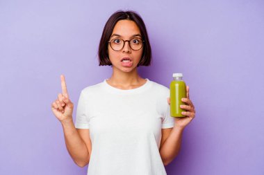 Mor arka planda izole edilmiş sağlıklı bir smoothie 'yi tutan genç melez kadın harika bir fikir, yaratıcılık kavramına sahip..