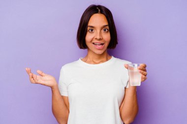 Mor zemin üzerinde bir bardak su tutan genç melez ırk şaşırdı ve şok oldu..