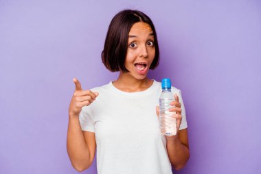 Mor arka planda izole edilmiş su şişesi tutan genç melez bir ırkın bir fikri var, ilham verici bir kavram..