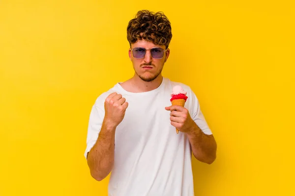 Jovem Caucasiano Comendo Sorvete Isolado Fundo Amarelo Mostrando Punho Para — Fotografia de Stock