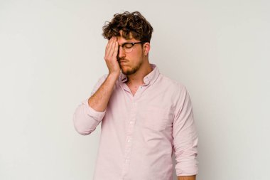 Beyaz arka planda izole olmuş genç beyaz bir adam başı ağrıyor, yüzüne dokunuyor..