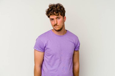 Beyaz arka planda izole edilmiş genç beyaz bir adam omuz silkiyor ve gözleri açık..