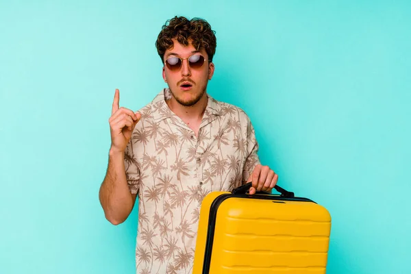 Young Traveler Man Holding Yellow Suitcase Blue Background Having Some — Stock Photo, Image