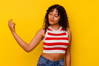 Sarı arka planda izole edilmiş genç, melez bir kadın seni işaret ediyor. Sanki davet ediliyormuş gibi..