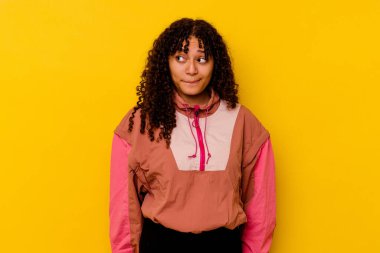 Pembe arka planda izole edilmiş genç melez kadın kafası karışmış, kuşkulu ve güvensiz hissediyor..