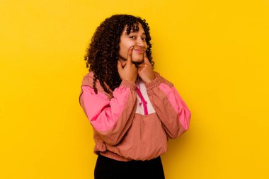 Pembe arka planda izole edilmiş genç melez kadın iki seçenek arasında kuşkulanıyor.