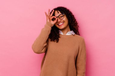 Pembe arka planda soyutlanmış genç melez bir kadın heyecanlı..