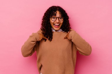 Pembe arka planda soyutlanmış genç melez bir kadın..